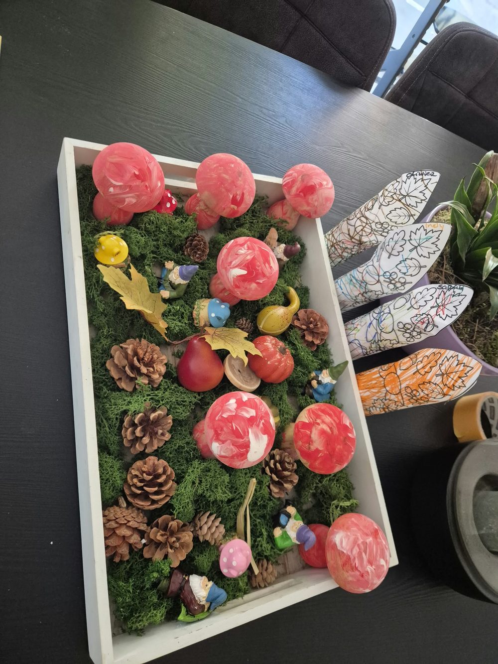 De zelfgemaakte herfst-thematafel met paddenstoelen, dennenappels en kabouters